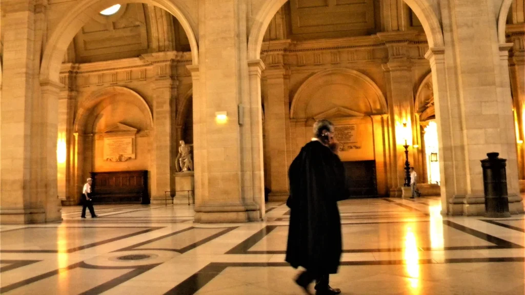 Salle des pas perdus du Palais de justice de Paris, un avocat en robe traverse le hall
