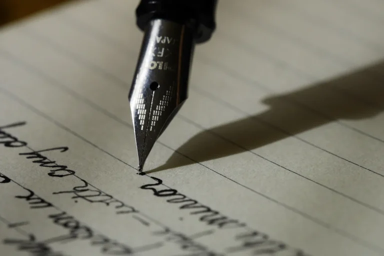 Plume d’un stylo qui écrit une lettre à la main