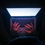 Personne regardant des vidéos sur un ordinateur portable dans le noir