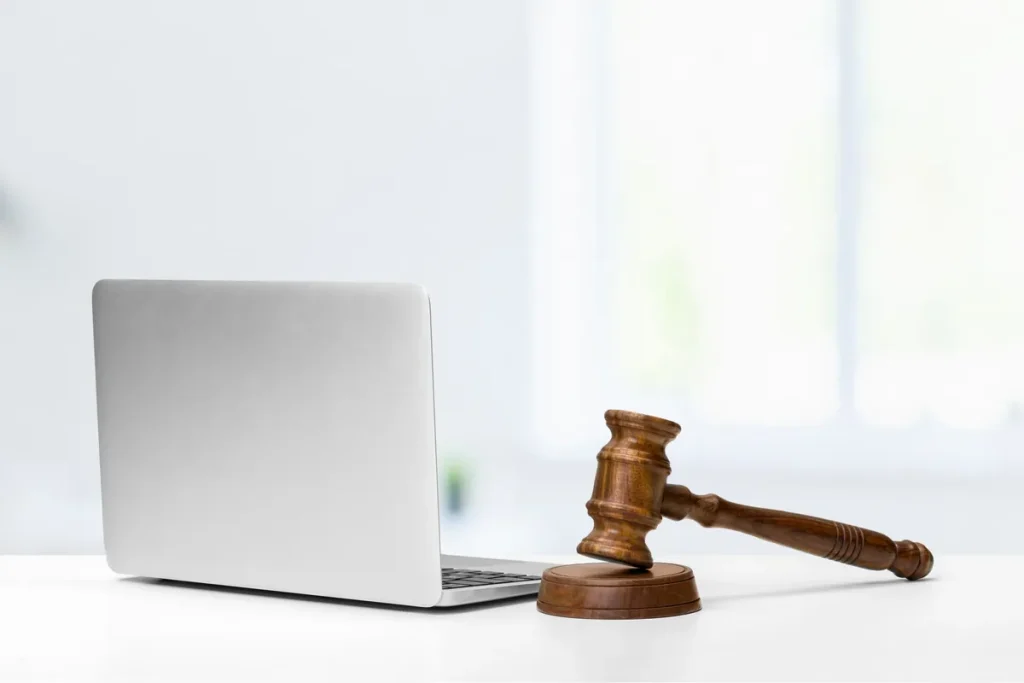 Marteau de juge posé à côté d'un ordinateur portable, litige autour d'un nom de domaine