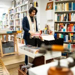 Jeune homme feuilletant des livres dans une librairie