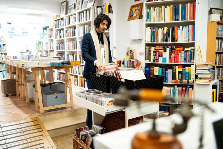 Jeune homme feuilletant des livres dans une librairie