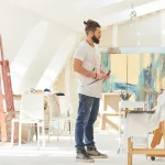 Artiste peintre tenant ses pinceaux dans son atelier, auteur d'œuvres protégées par le droit d'auteur