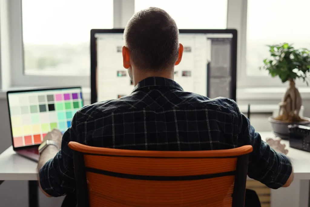Homme travaillant sur un site web depuis son ordinateur dans un bureau lumineux