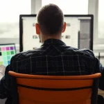 Homme travaillant sur un site web depuis son ordinateur dans un bureau lumineux