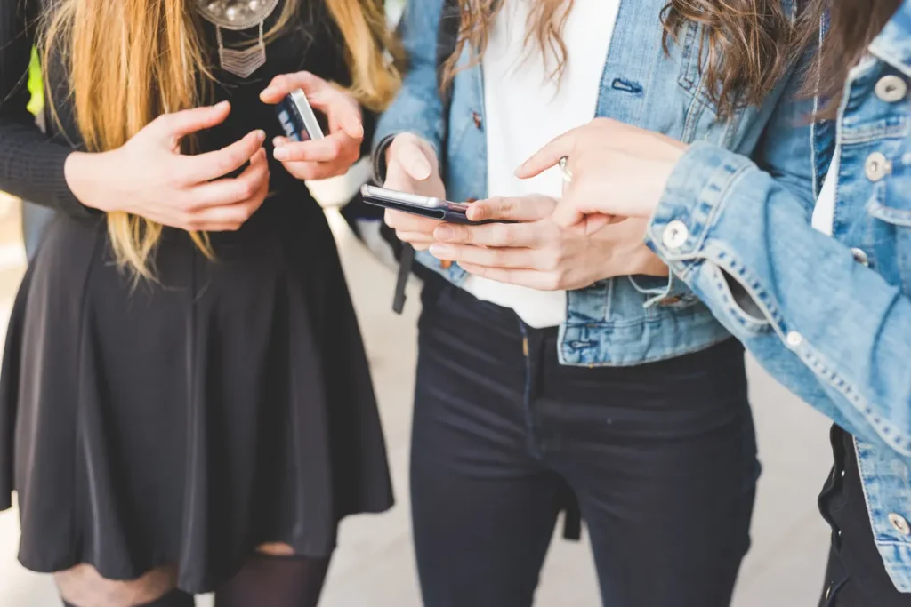 Jeunes consultant leur smartphone pour échanger sur un forum en ligne