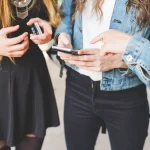 Jeunes consultant leur smartphone pour échanger sur un forum en ligne