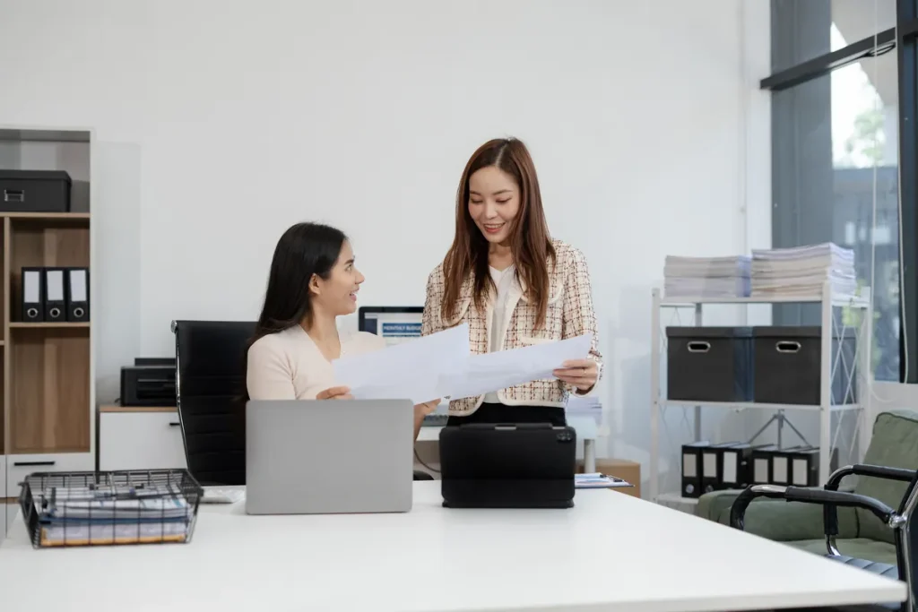Deux femmes travaillant ensemble sur des documents dans un bureau moderne