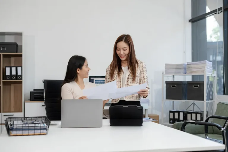 Deux femmes travaillant ensemble sur des documents dans un bureau moderne