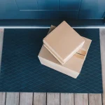 Colis livrés devant une porte d'entrée bleue après un achat en ligne