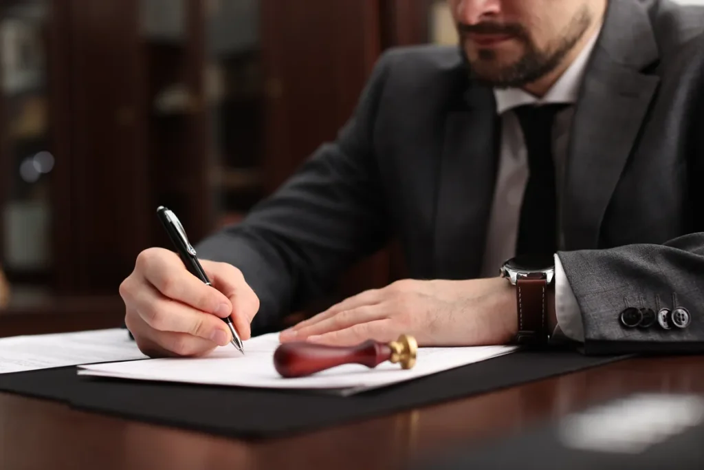 Homme signant un acte juridique à son bureau