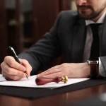 Homme signant un acte juridique à son bureau