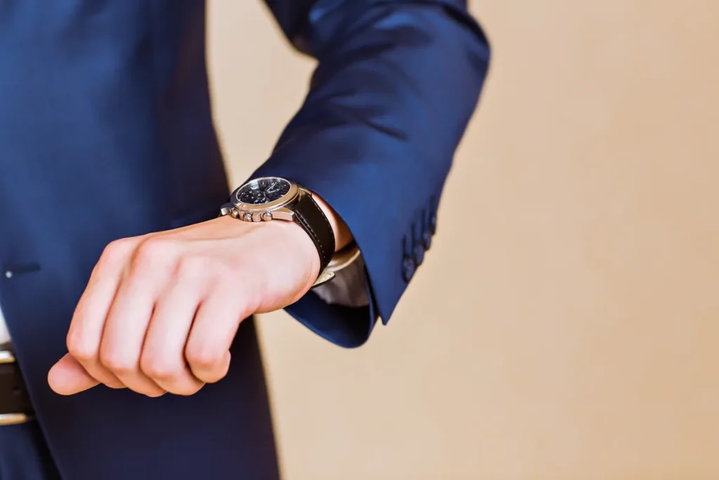 Homme en costume regardant sa montre-bracelet
