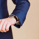 Homme en costume regardant sa montre-bracelet