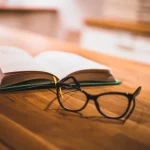 Livre ouvert et lunettes posés sur une table, consultation du Code du travail