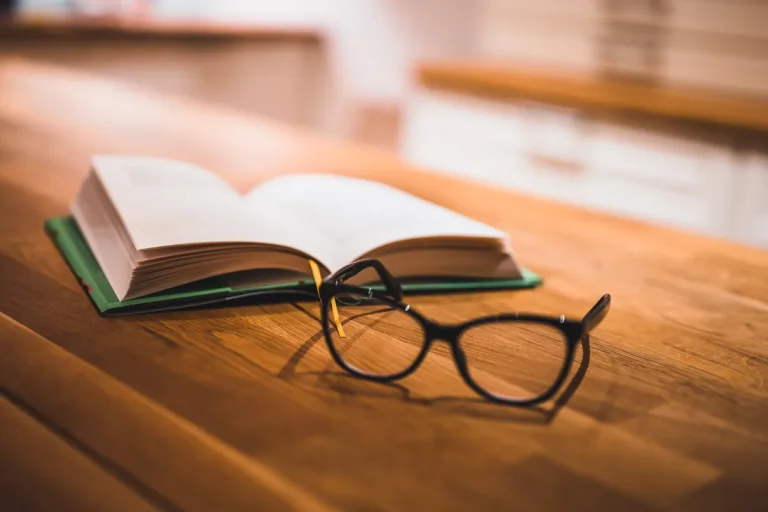 Livre ouvert et lunettes posés sur une table, consultation du Code du travail