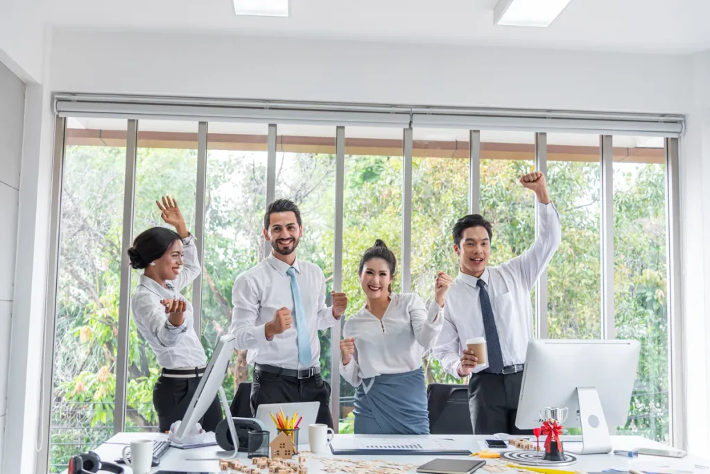 Équipe joyeuse célébrant une réussite au bureau, bien-être et psychologie positive au travail
