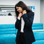 Jeune femme en blazer dans un bureau moderne, tenue vestimentaire professionnelle