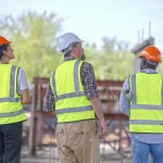 Ouvriers en casque et gilet de sécurité sur un chantier du BTP