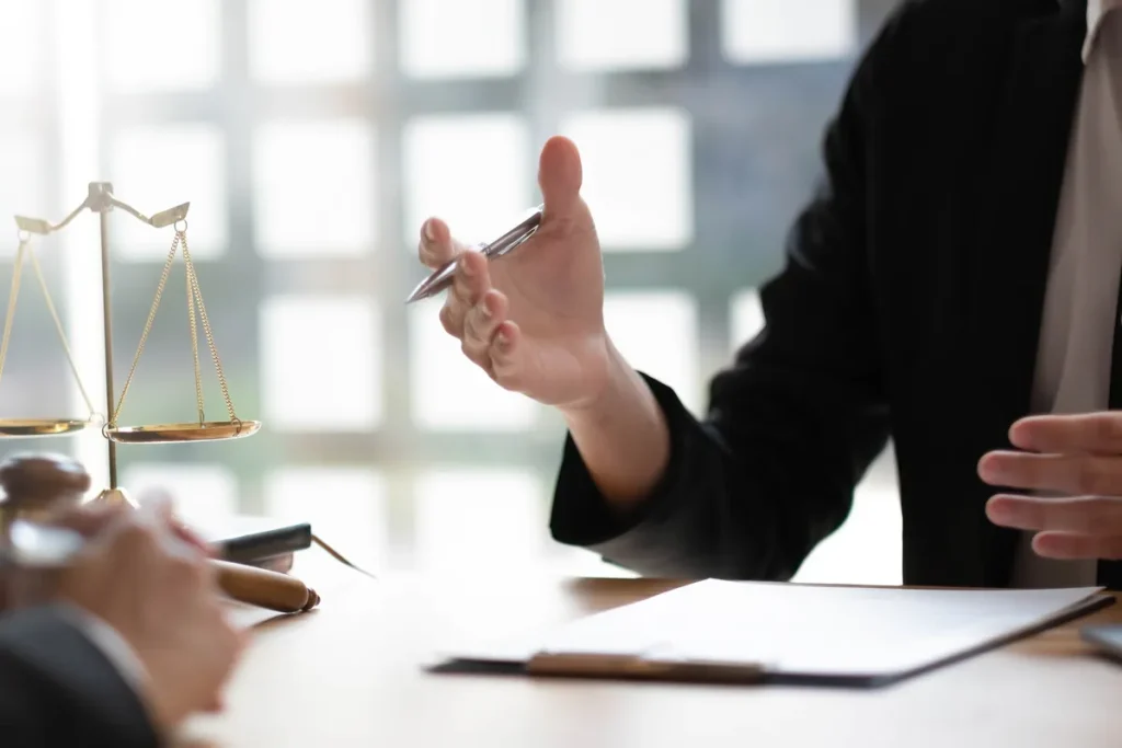 Avocat conseillant un client près d'une balance de la justice, au sujet d'un préjudice