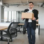 Salarié rangeant ses affaires dans un carton après la rupture de son contrat de travail