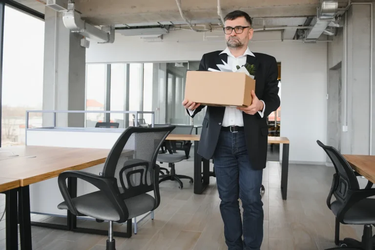 Salarié rangeant ses affaires dans un carton après la rupture de son contrat de travail