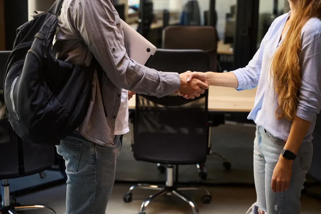 Poignée de main entre deux collègues dans un bureau, symbole des droits du salarié