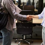 Poignée de main entre deux collègues dans un bureau, symbole des droits du salarié