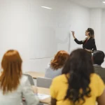 Formatrice devant un tableau blanc lors d'une session de formation professionnelle