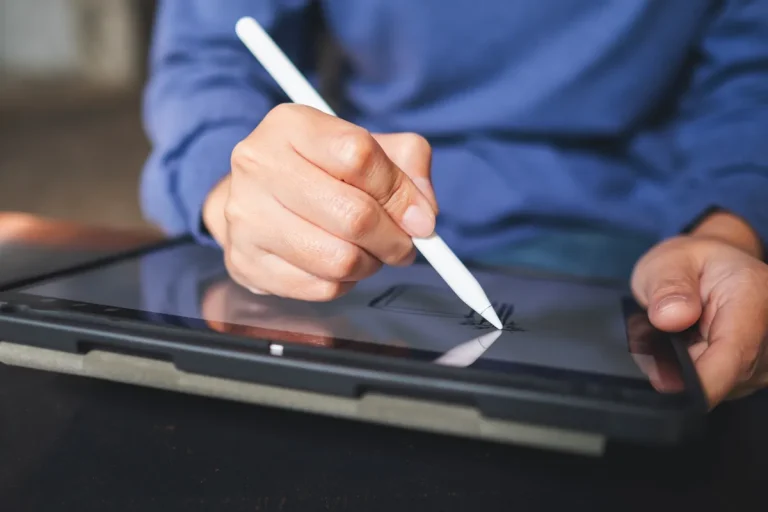 Main utilisant un stylet sur une tablette, écrit électronique