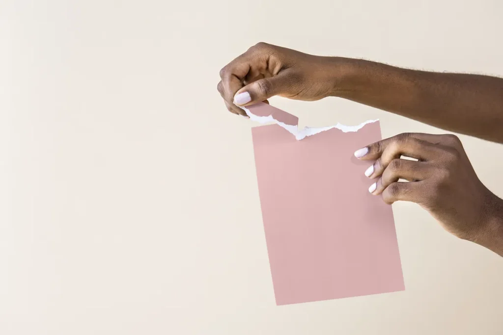 Mains déchirant une feuille de papier, image de la résiliation d'un contrat