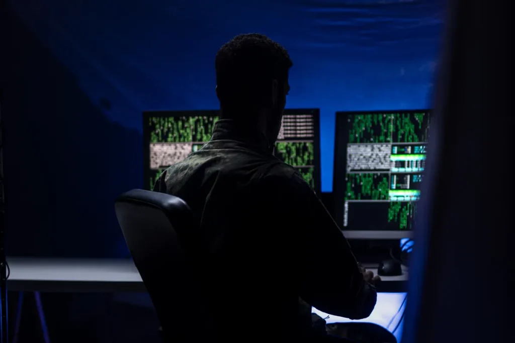 Développeur travaillant de nuit devant plusieurs écrans de code