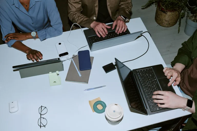 Développeurs collaborant sur leurs ordinateurs portables à un bureau partagé