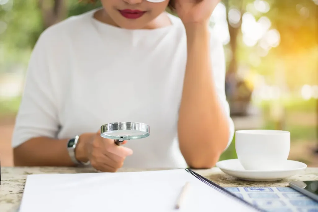 Femme examinant un contrat à la loupe pour repérer des clauses abusives