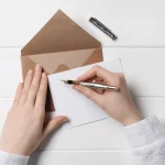 Mains rédigeant une lettre de résiliation au stylo