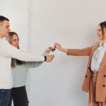 Couple recevant les clés de son logement des mains de l'agent immobilier