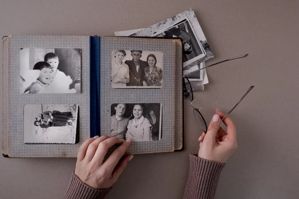 Album de famille ouvert sur de vieilles photos en noir et blanc, souvenirs liés à une succession