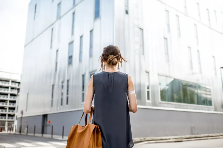 Femme marchant en ville avec son sac, quittant son emploi après une démission