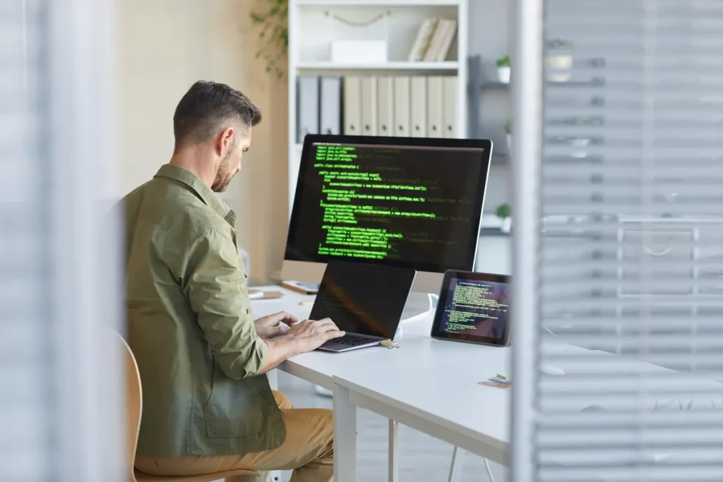 Développeur web travaillant sur un site devant son écran, protection du nom de domaine