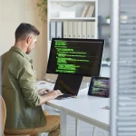 Développeur web travaillant sur un site devant son écran, protection du nom de domaine