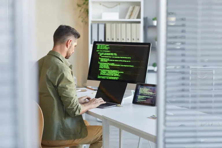 Développeur web travaillant sur un site devant son écran, protection du nom de domaine