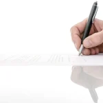 Homme signant un contrat au stylo sur un bureau, engagement contractuel