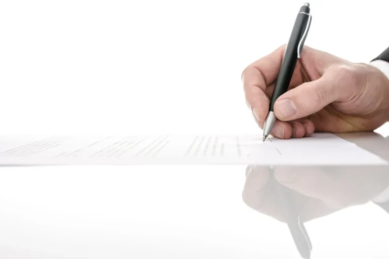 Homme signant un contrat au stylo sur un bureau, engagement contractuel