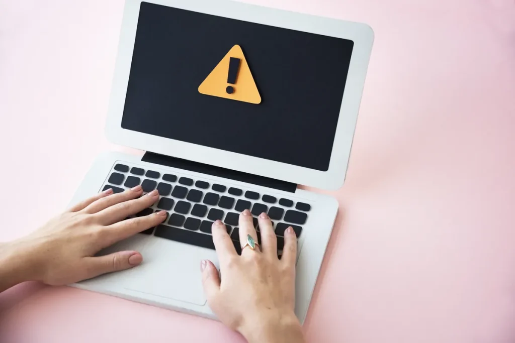 Point d'exclamation d'alerte sur un écran d'ordinateur, signalement d'un contenu illicite
