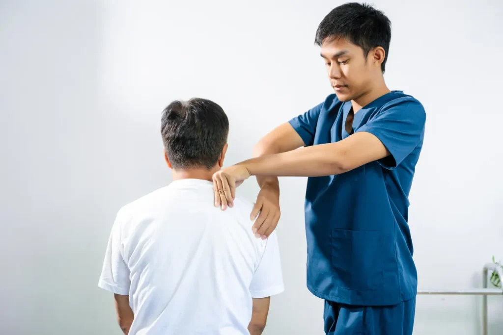 Kinésithérapeute soignant l'épaule d'un patient atteint d'une tendinopathie du supra-épineux