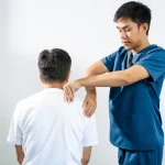 Kinésithérapeute soignant l'épaule d'un patient atteint d'une tendinopathie du supra-épineux
